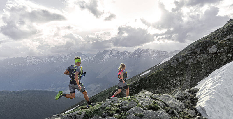 Calcetines técnicos deportivos Alpine, con paisaje de montañas.